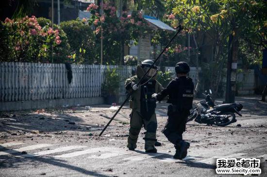 图为印尼拆弹小组在袭击现场进行检查。(法新社)